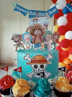 a birthday cake with cupcakes and pirate flags on the table next to it