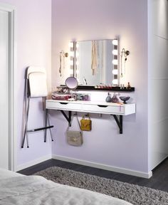 there is a vanity with lights on it and a mirror above the sink in this room