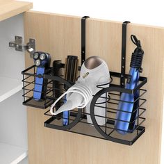 a kitchen cabinet door is open and there are hairdryers in the holder on the shelf