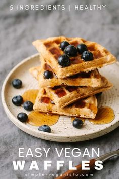 waffles stacked on top of each other with syrup and blueberries in the middle