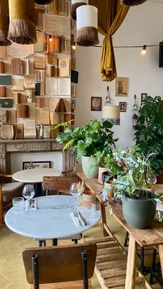 a room filled with lots of wooden tables and chairs next to plants on the wall