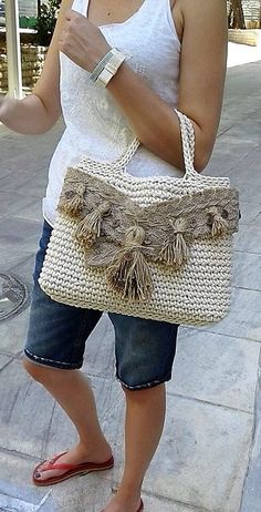 a woman is standing on the sidewalk holding a purse