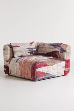 a multicolored couch sitting on top of a white floor