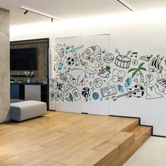 a living room with white walls and wooden flooring next to a tv mounted on the wall