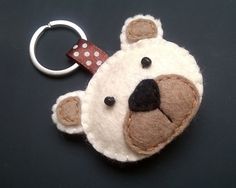 a keychain with a teddy bear on it's face and polka dots