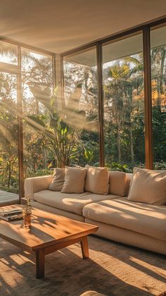 the sun shines through large windows into a living room with couches and coffee table