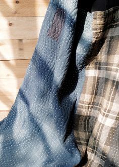 a quilted blanket laying on top of a wooden floor