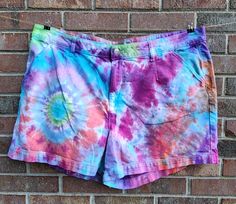 tie dye shorts hanging on a brick wall