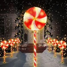 a lighted candy cane in front of a house