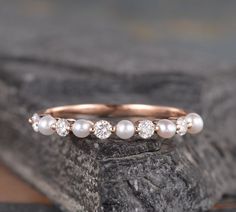 a close up of a ring with pearls on it sitting on a piece of rock