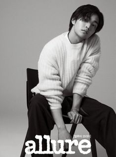 a young man sitting on top of a chair with the words allure written in white