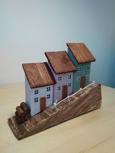 three small houses are on a wooden plank