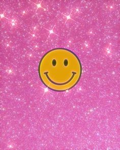 a smiley face on a pink background with stars and sparkles in the sky behind it