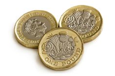 three british pound coins sitting on top of each other in front of a white background