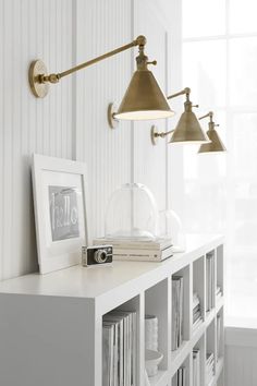 a white shelf with some books and lights on it