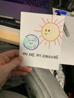 someone holding up a card that says you are my sunshine and an image of the earth