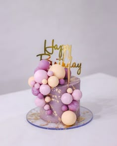 a birthday cake decorated with balloons and a happy birthday sign on it's top