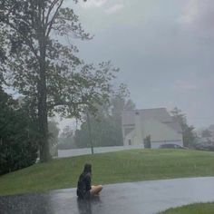 a person sitting in the rain with an umbrella