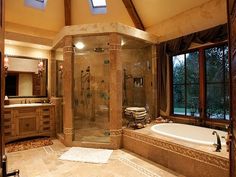 a large bathroom with a walk in shower next to a bathtub and double sinks