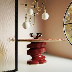 a table with a plate on it in front of a window and a chandelier hanging from the ceiling