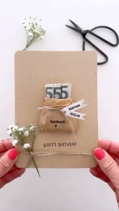 someone holding up a birthday card with flowers on it