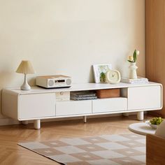 a living room with a white entertainment center in it's centerpiece and a clock on the wall