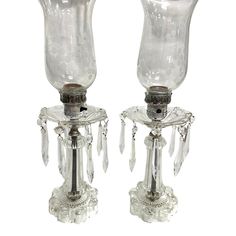 two clear glass candlesticks with crystal beads on each candle holder, one is holding a silver plate