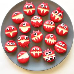 red and white decorated donuts with googly eyes on a gray plate, ready to be eaten