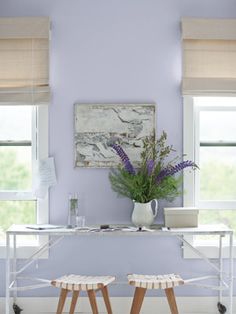 two wooden stools sitting in front of a table with flowers on top of it