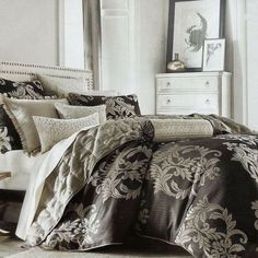 a bedroom with a bed covered in black and white sheets, pillows and comforter