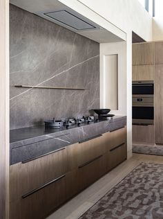 a modern kitchen with marble counter tops and stainless steel appliances in the middle of the room