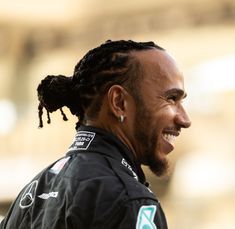 a close up of a person with dreadlocks on his head and wearing a black jacket