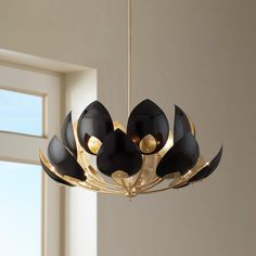 a black and gold chandelier hanging from a ceiling in a room with windows