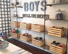 a room filled with lots of wooden boxes and shelves next to a wall mounted sign that says boys will be boys