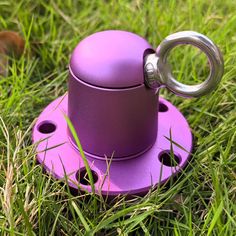 a purple cup holder sitting on top of green grass