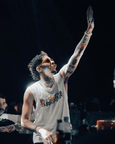 a man with his hands up in the air while standing on stage at a concert