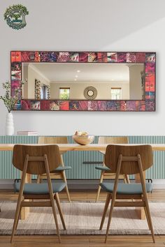 a dining room table with chairs and a large mirror on the wall above it,