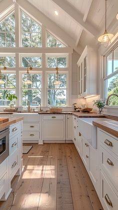 a large kitchen with white cabinets and wood flooring is pictured in this image from the inside