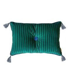 a green and blue striped pillow with tassels on the front, sitting against a white background