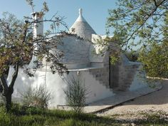 an old building with a white dome on the side and trees in front of it