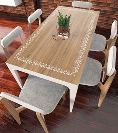 a wooden table with chairs around it and a potted plant on the table top