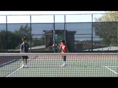 two men standing on a tennis court holding racquets