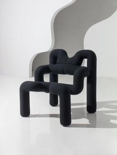 two black chairs sitting next to each other on a white floor