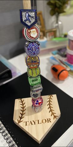 a bunch of bracelets that are on top of a wooden stand in front of a notebook