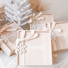 four wooden boxes with snowflakes on them sitting next to a white christmas tree