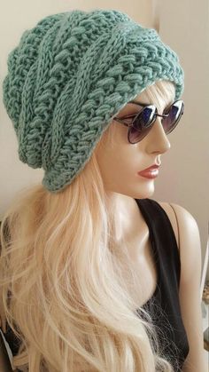 a mannequin head wearing sunglasses and a green knitted hat on top of a wig