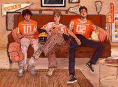 three boys sitting on a couch in an orange and white football uniform