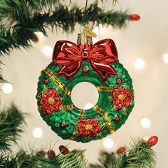 a green wreath ornament hanging from a christmas tree