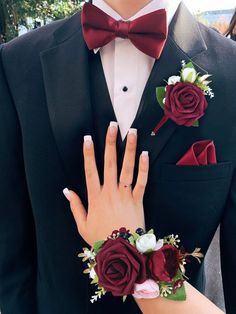 a close up of a person wearing a suit and tie with flowers on his lapel