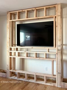 an entertainment center made out of wooden pallets with a flat screen tv mounted on the wall